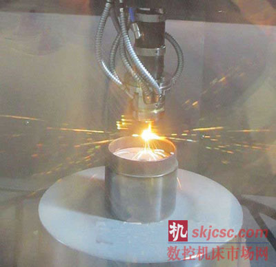 “LASERTEC 65 3D”進行增材製造時（shí）的情形。噴射金屬粉末利（lì）用激光使粉末熔融（róng）凝（níng）固